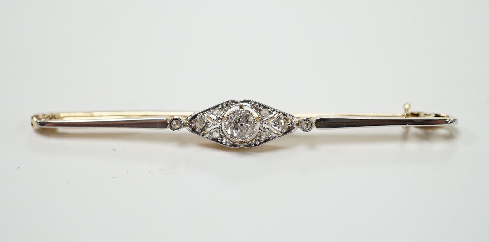 An Edwardian yellow metal and diamond cluster set bar brooch, 55mm, gross weight 3.6 grams. Condition - good